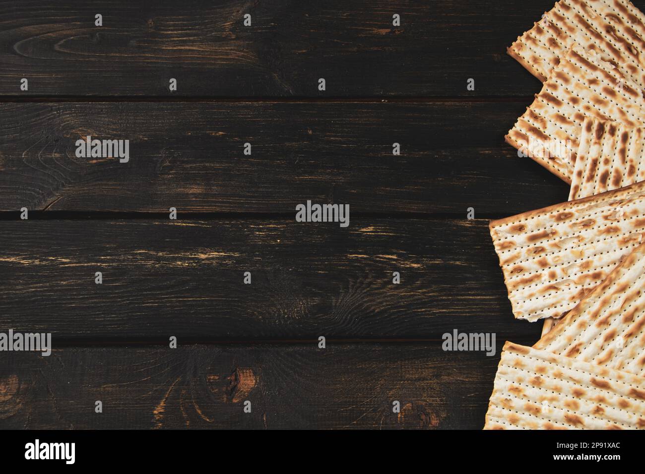 Matzo bread on dark wooden background. Happy Passover. Traditional Jewish regilious holiday Pesach. Copy space. Stock Photo