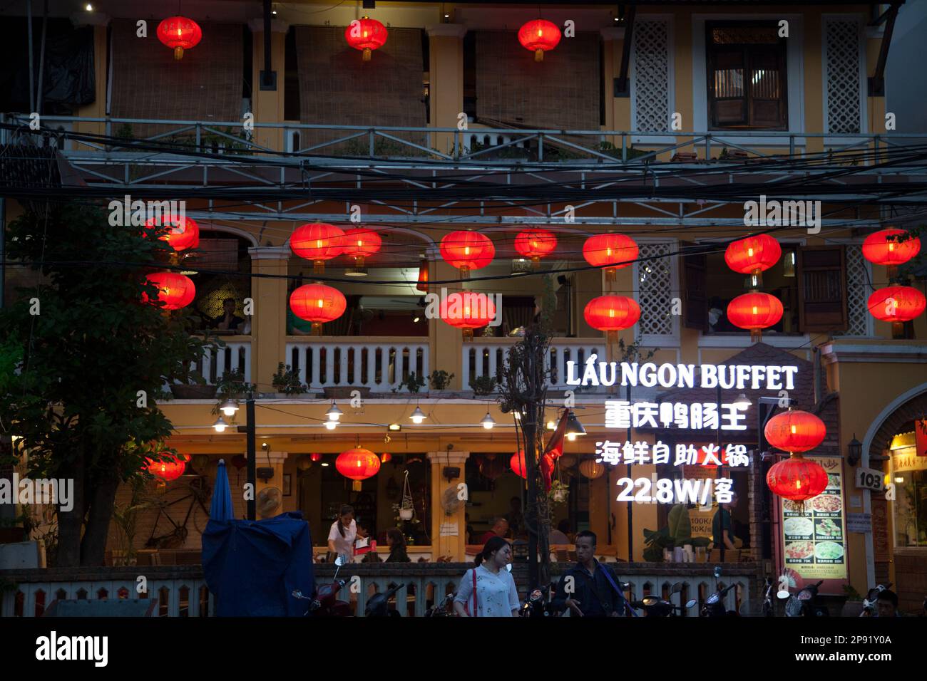 Nha Trang, Vietnam - March 31, 2018: Asian restaurant exterior decorated with red paper lanterns. People eating at a Chinese buffet, view of windows f Stock Photo