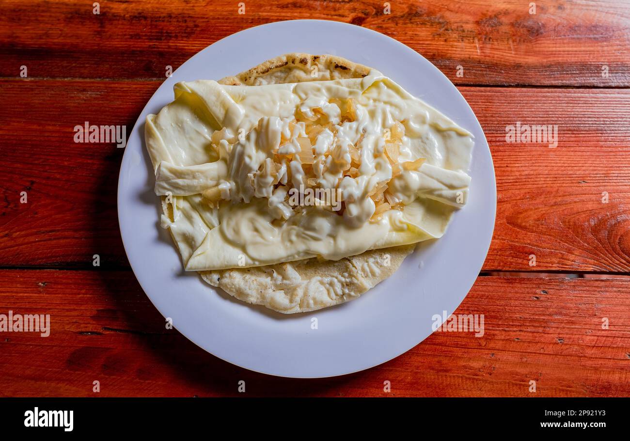 Top View of traditional Cheese with Pickled Onion, Traditional cheese dish with pickled onion and cream. Concept of typical foods of latin america Stock Photo