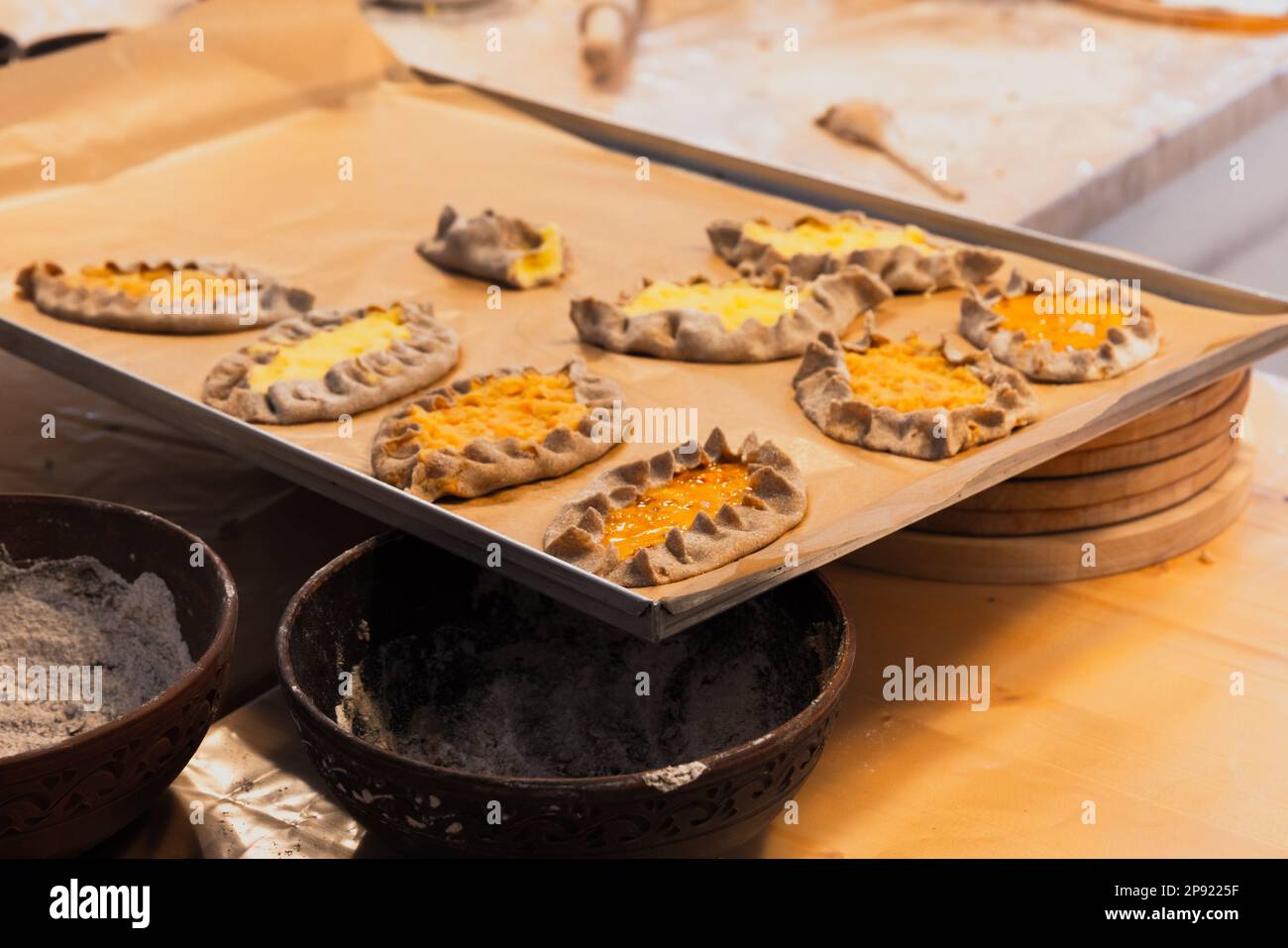 Karelian pasties are in a tray before bake, close up photo with selective soft focus Stock Photo