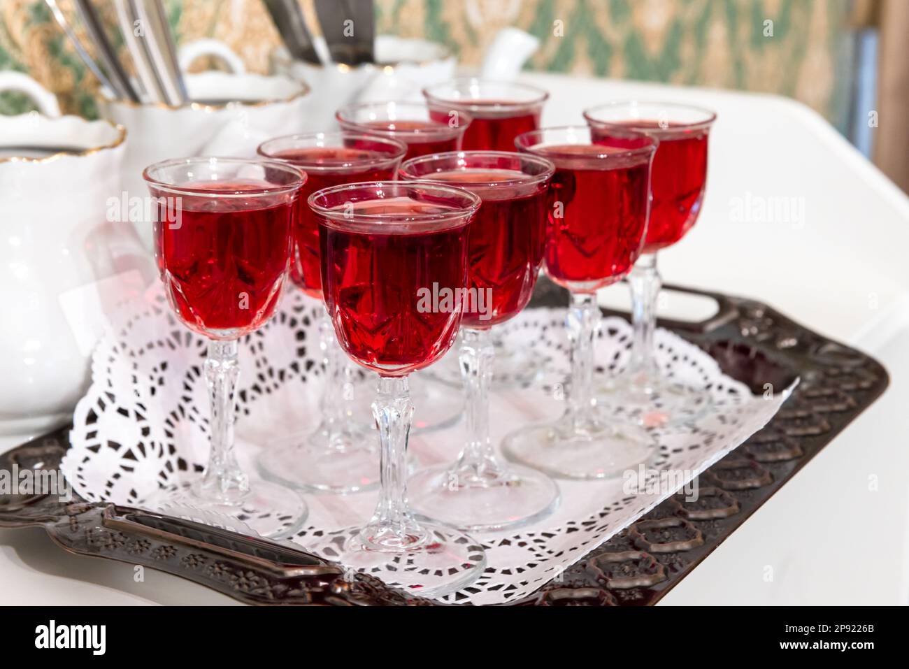Crystal glasses of cranberry tincture stand on a table, close up photo with selective soft focus Stock Photo
