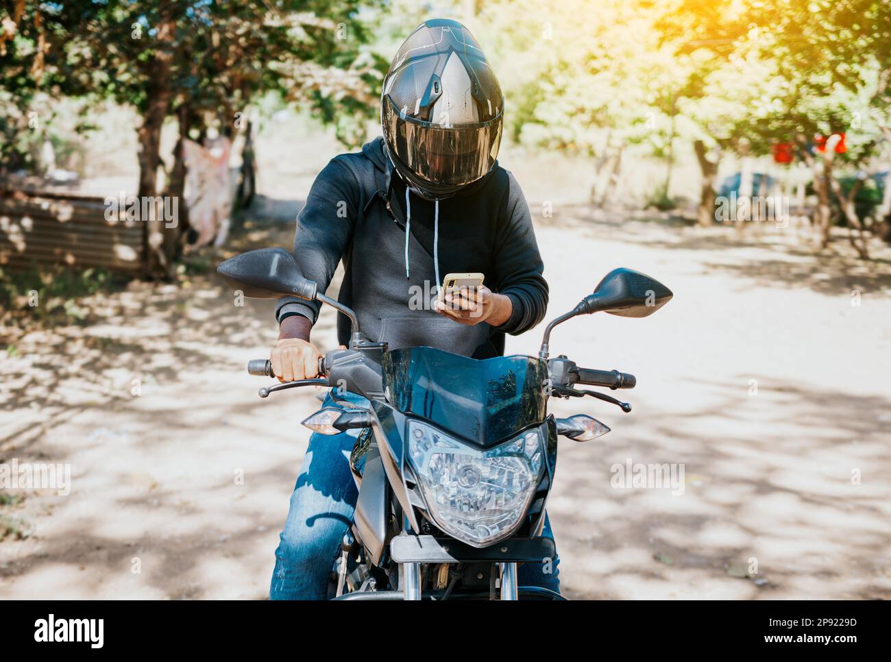 Man on motorbike texting while driving. Motorcyclist on motorcycle using  cell phone outdoors. Concept of distracted motorcyclist with cell phone  Stock Photo - Alamy