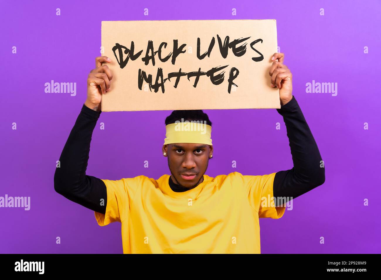 Black Ethnic Man In Yellow Clothes On A Purple Background Pointing Holding A Sign Black Lives