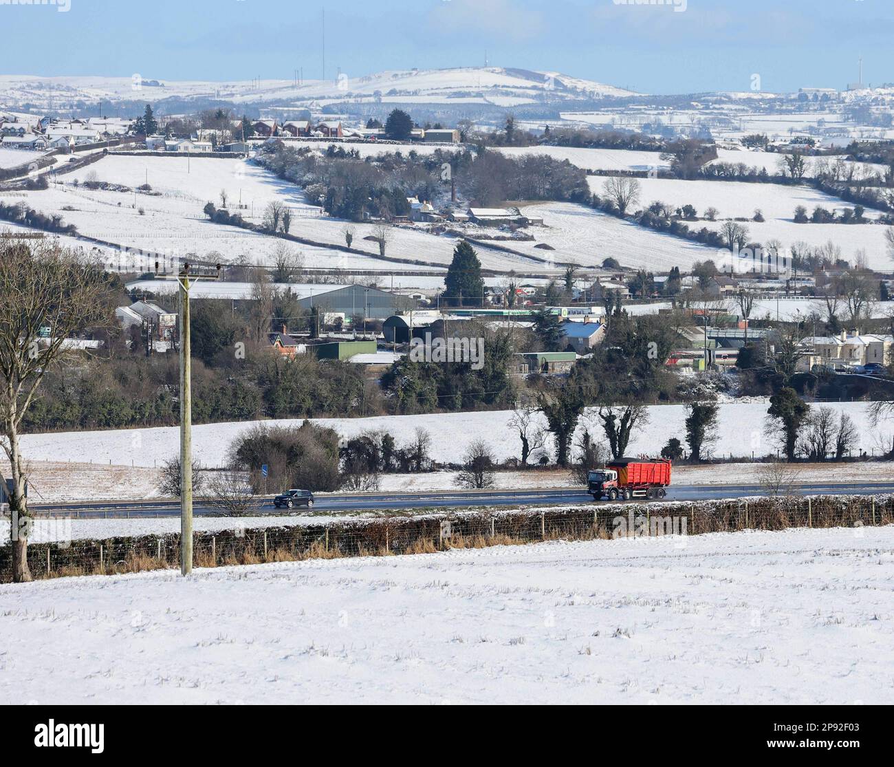 Moira, County Down, Northern Ireland, UK. 10 Mar 2023. UK weather - a bright sunny day with blue sky after a lot of overnight snow. Snow in the surrounding countryside viewed from Moira Demesne with traffic moving along the M1 motorway in Northern Ireland. Credit: CAZIMB/Alamy Live News. Stock Photo