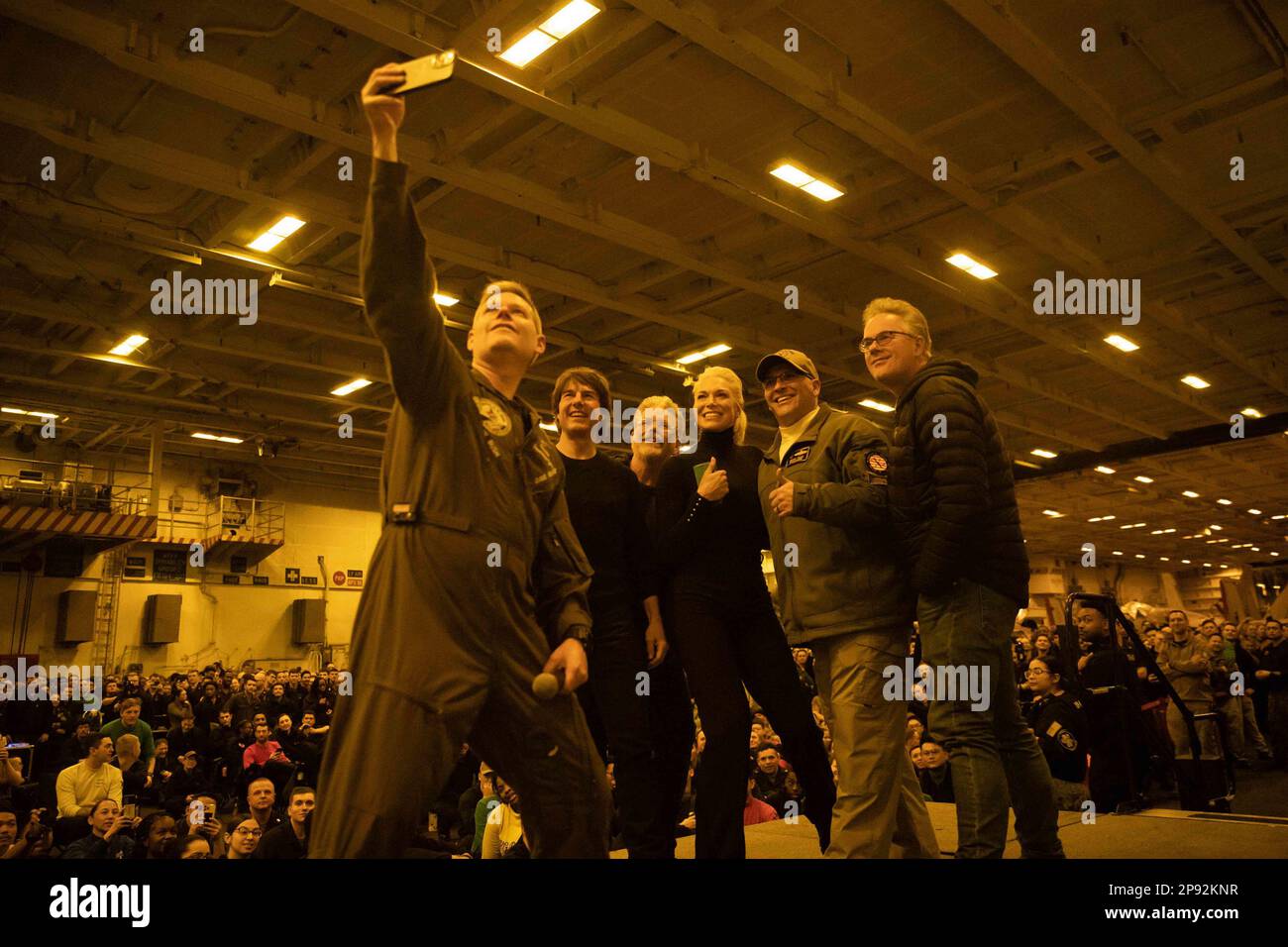 Capt. Dave Pollard, commanding officer aboard the Nimitz-class aircraft carrier USS George H.W. Bush (CVN 77), takes an on-stage selfie with Tom Cruise, right, Christopher McQuarrie, center right, Hannah Waddingham, center, Eddie Hamilton, left center, Rear Adm. Dennis Velez, commander Carrier Strike Group (CSG) 10 and the George H.W. Bush CSG, and Sailors during a visit to the ship, on March 2, 2023, while filming scenes for 'Mission: Impossible - Dead Reckoning Part Two.' The George H.W. Bush Carrier Strike Group is on a scheduled deployment in the U.S. Naval Forces Europe area of operations Stock Photo