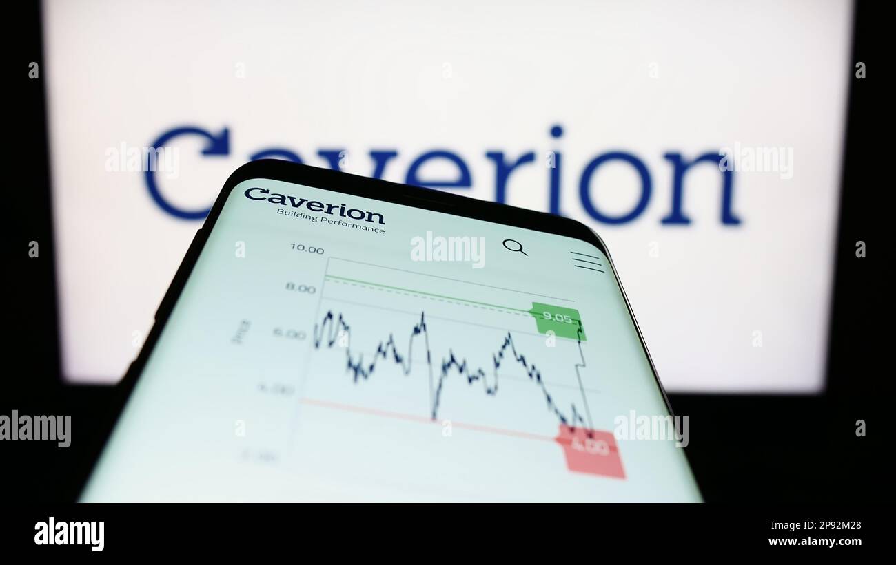 Mobile phone with webpage of building technology company Caverion Oyj on screen in front of business logo. Focus on top-left of phone display. Stock Photo
