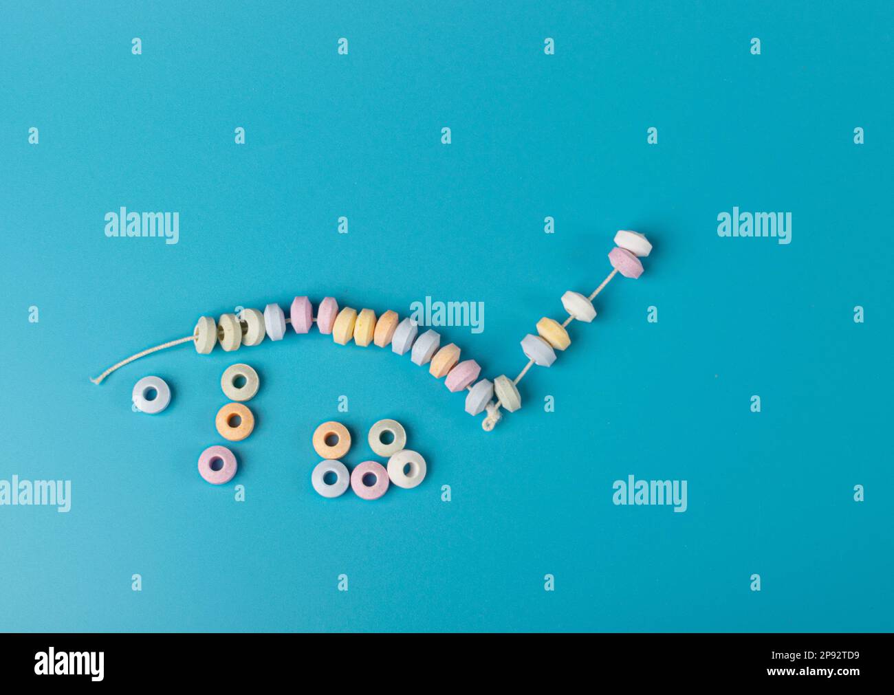 Tablet Candies Bracelet, Compressed Sugar Powder Confectionery, Dextrose Candy Necklace Parts, Lozenges on Blue Background Stock Photo