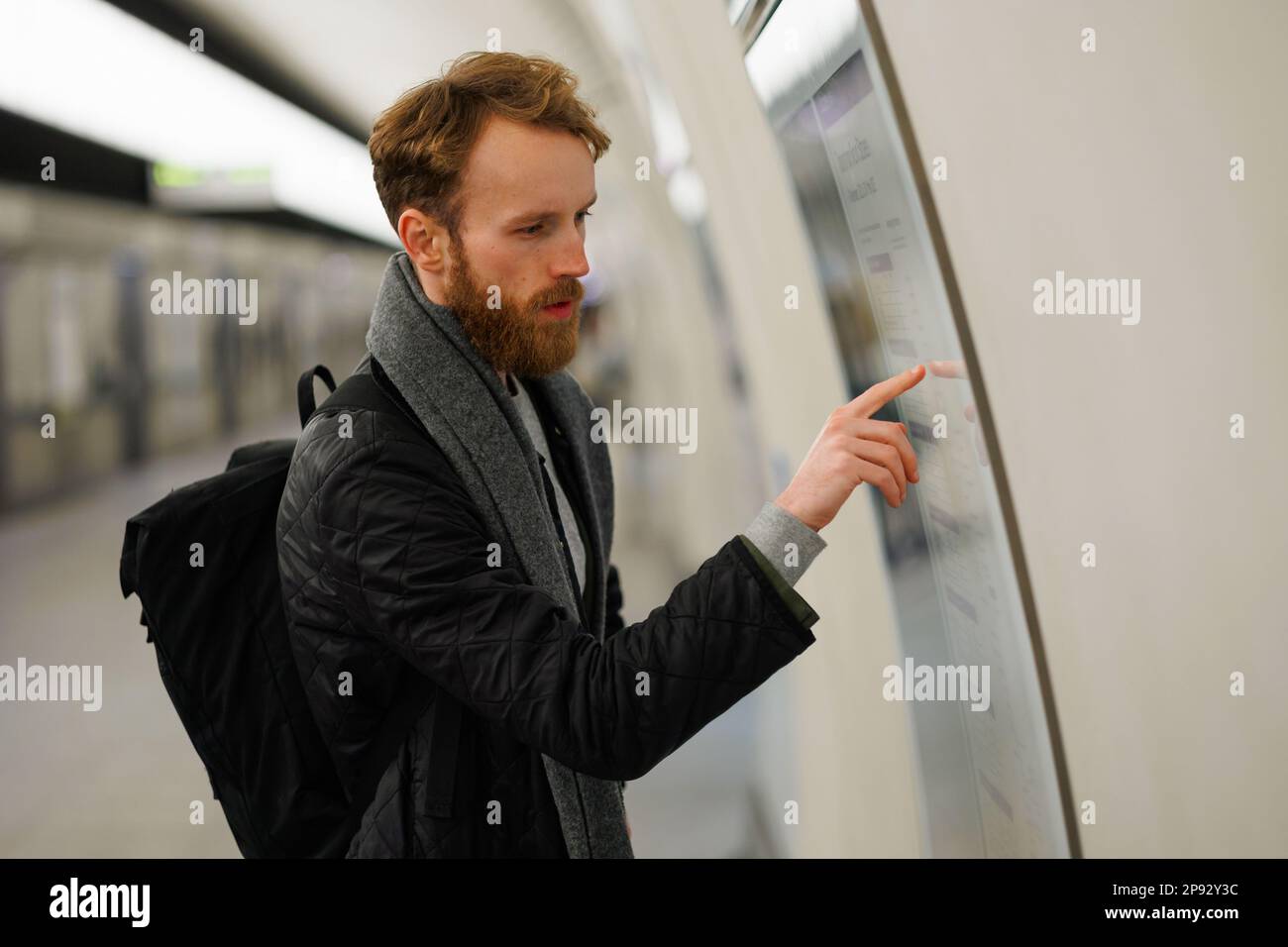 Bearded man looks at a subway train map Stock Photo