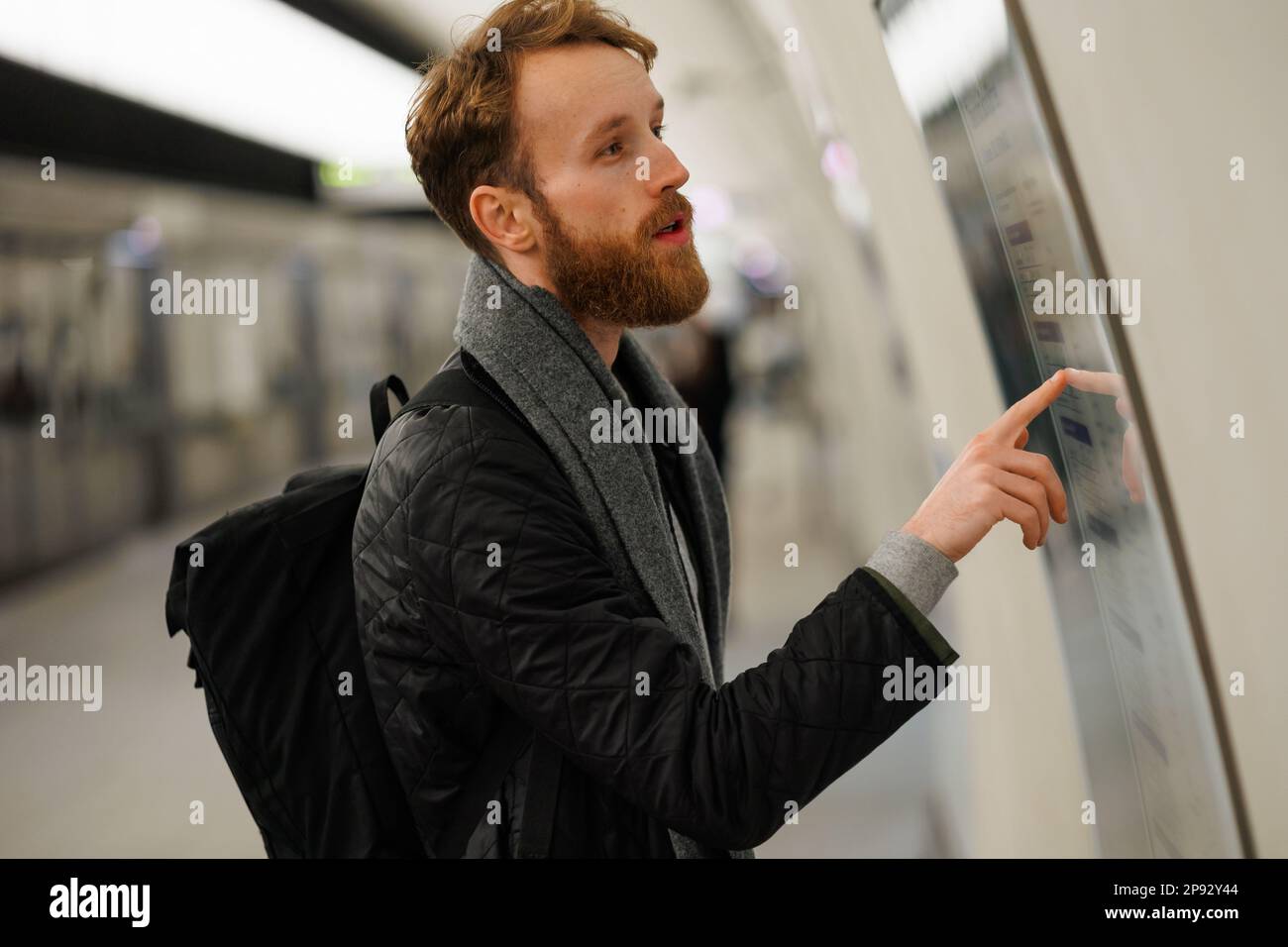 Bearded man looks at a subway train map Stock Photo