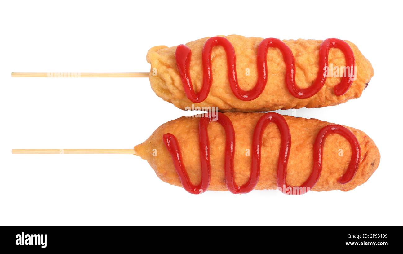 Delicious deep fried corn dogs with ketchup on white background, top