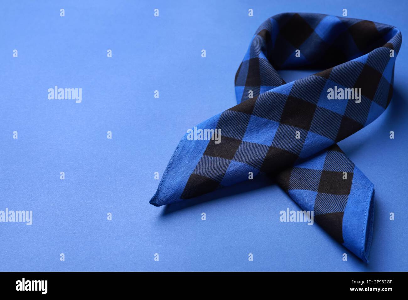 Folded bandana with check pattern on blue background. Space for text Stock Photo