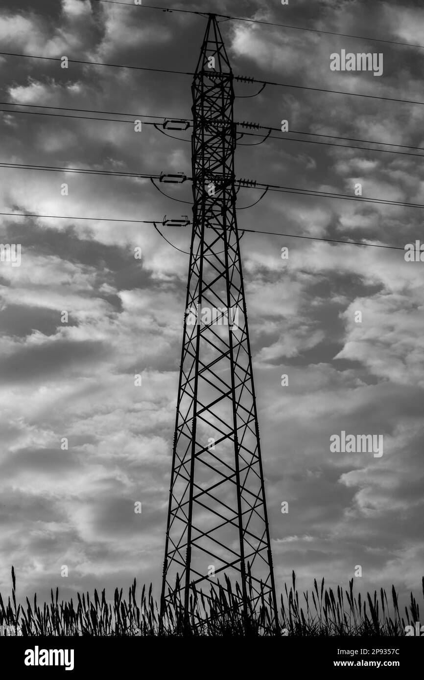 Silhouette of a high voltage cable pylon in the countryside Stock Photo