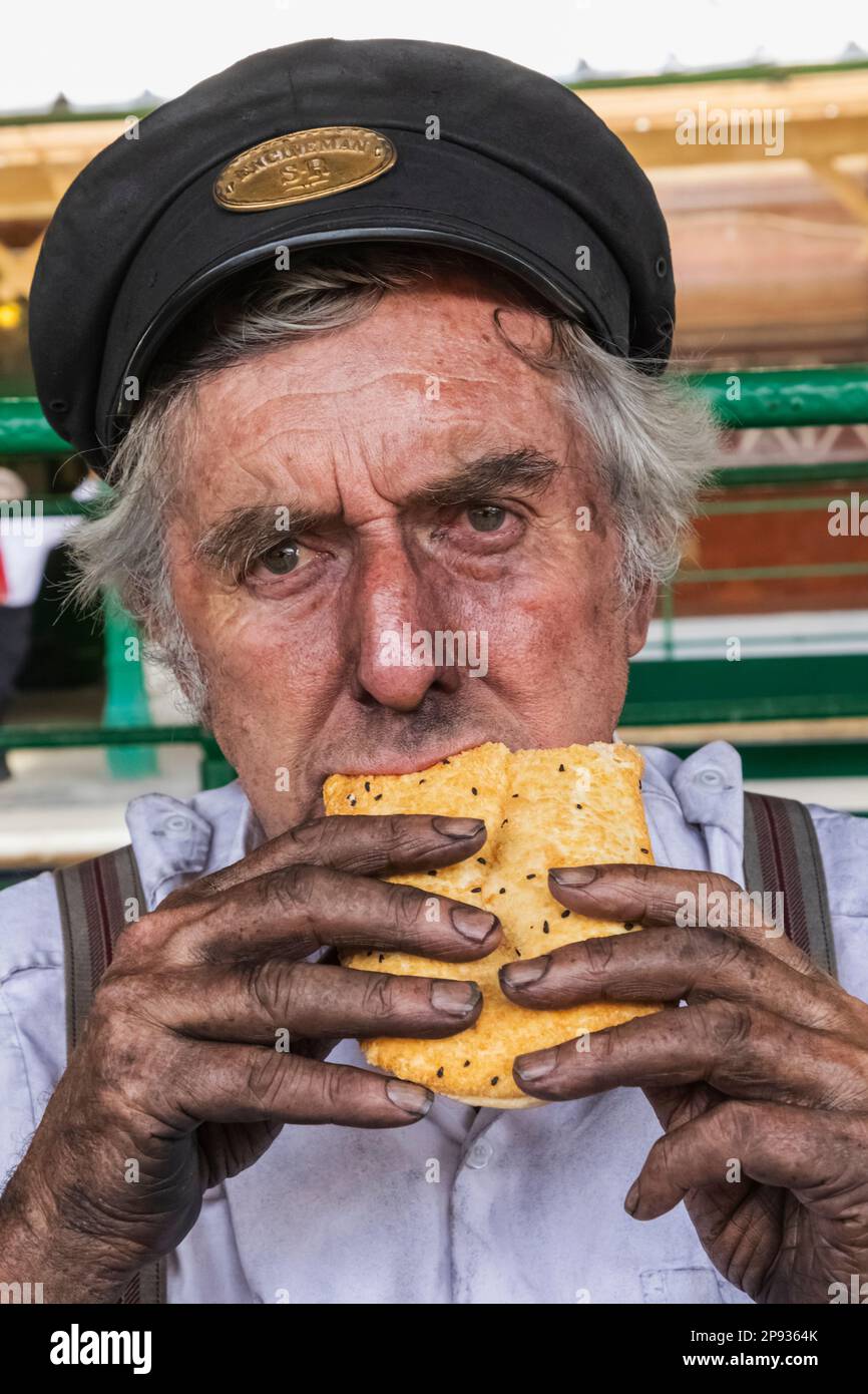England, Sussex, Bluebell Railway, Horsted Keynes Station, Portrait of Train Drivers Eating a Pastie Stock Photo