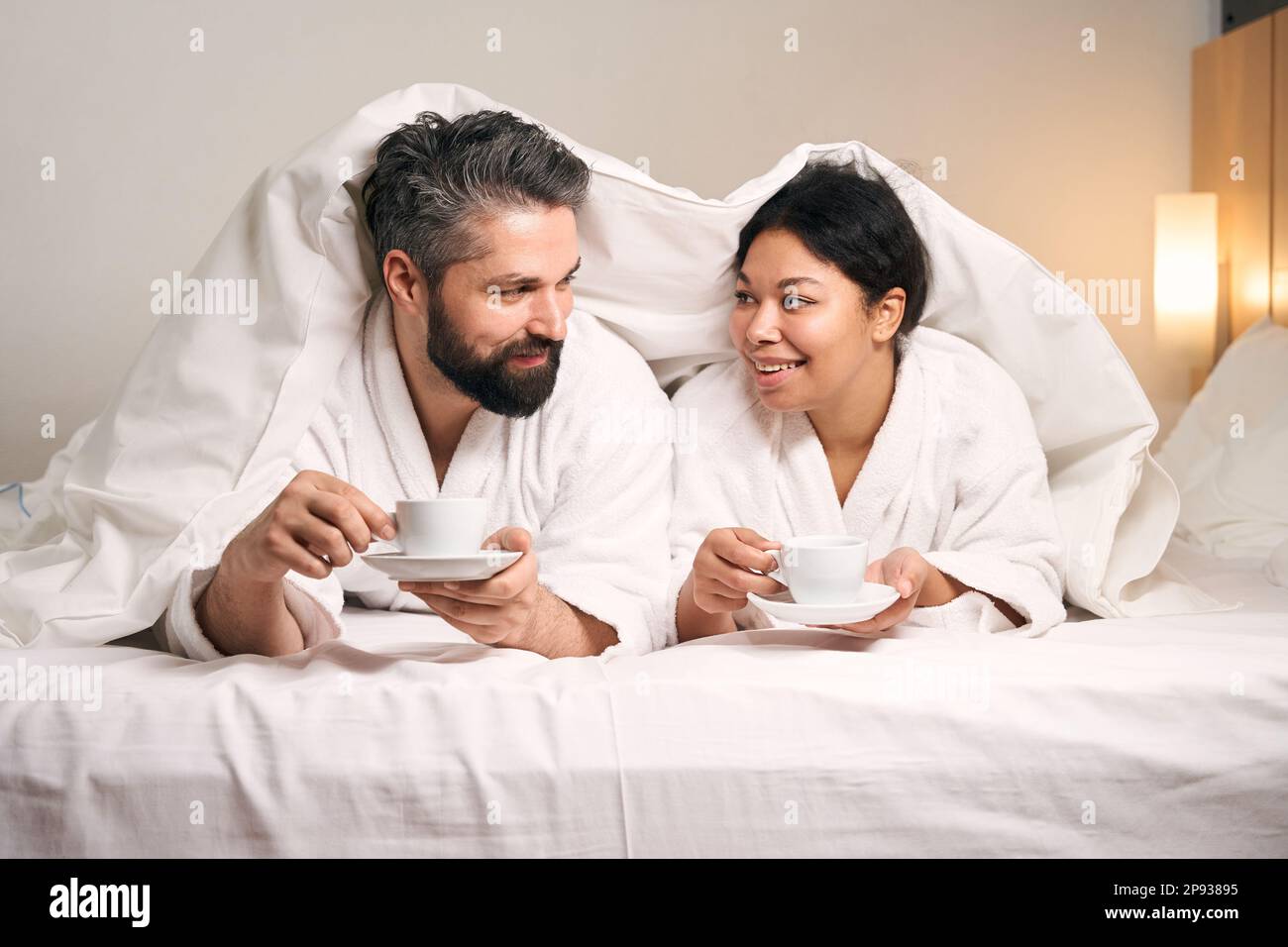 Man and his female companion drinking coffee in hotel room Stock Photo