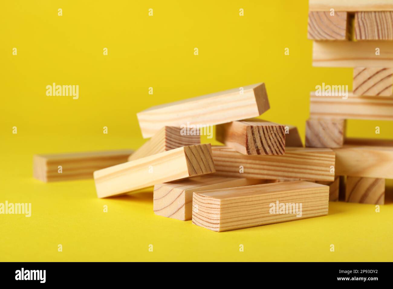Wooden Jenga blocks on yellow background, closeup Stock Photo Alamy