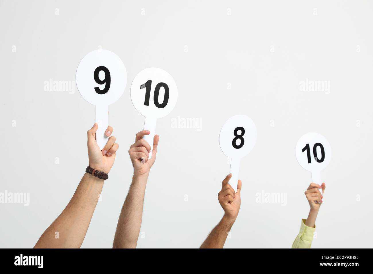 Panel of judges holding different score signs on white background