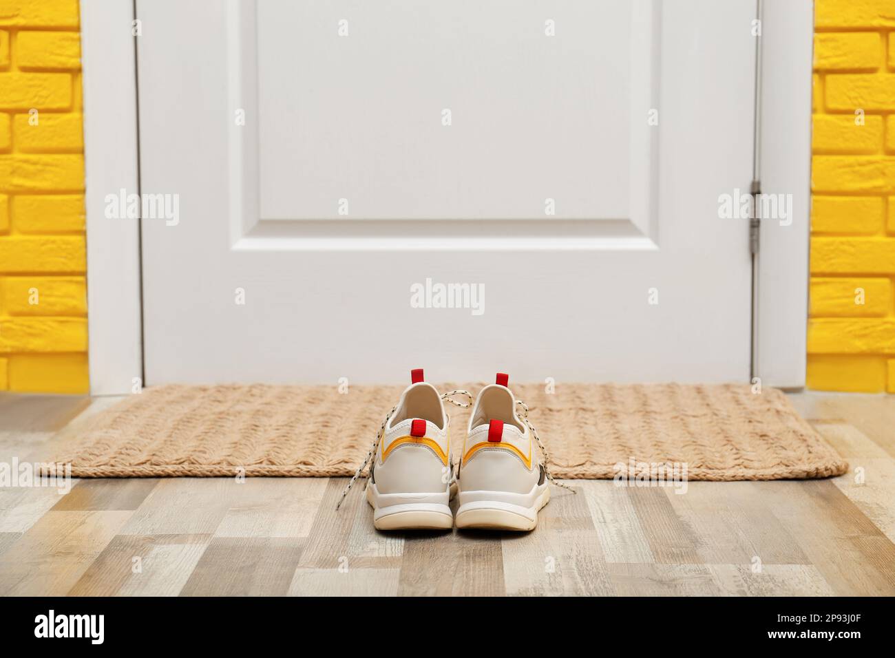 Shoes and mat near door in hallway Stock Photo Alamy