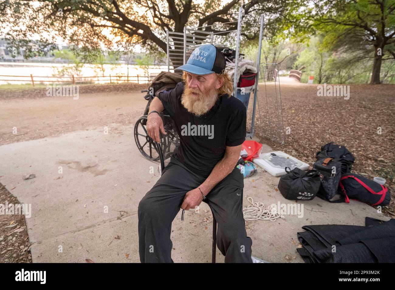 A homeless man, who wished not to be identified, sits with most of his belongings at the hike and bike trail along the north shore of Lady Bird Lake in downtown Austin on March 9, 2023. The man, who has camped along the shoreline for about 9 months, was finally asked to leave by crews building a split-rail fence and adding lighting following a recent drowning death in the lake. ©Bob Daemmrich Stock Photo