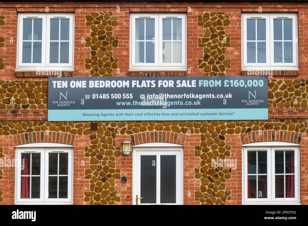 Ten One Bedroom Flats For Sale sign on building in Norfolk village. Stock Photo