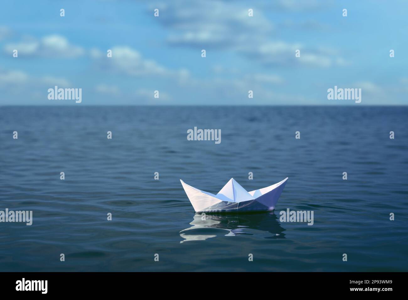 White paper boat floating on calm sea Stock Photo - Alamy