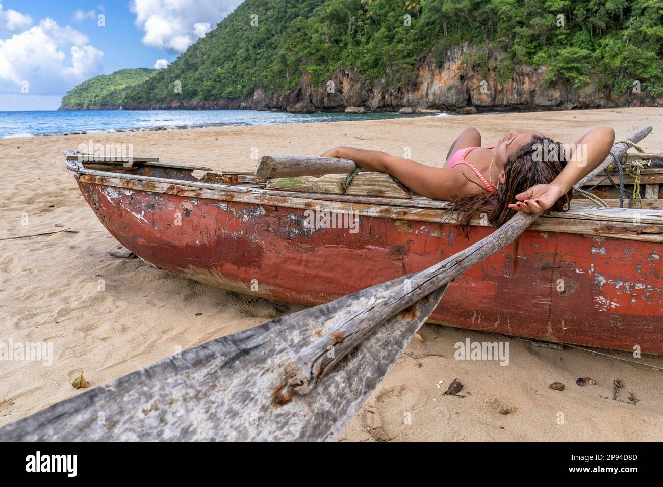 North America, Caribbean, Greater Antilles, Hispaniola Island, Dominican Republic, Sama, Playa El Valle, pretty woman lying in old wooden boat on beach Stock Photo