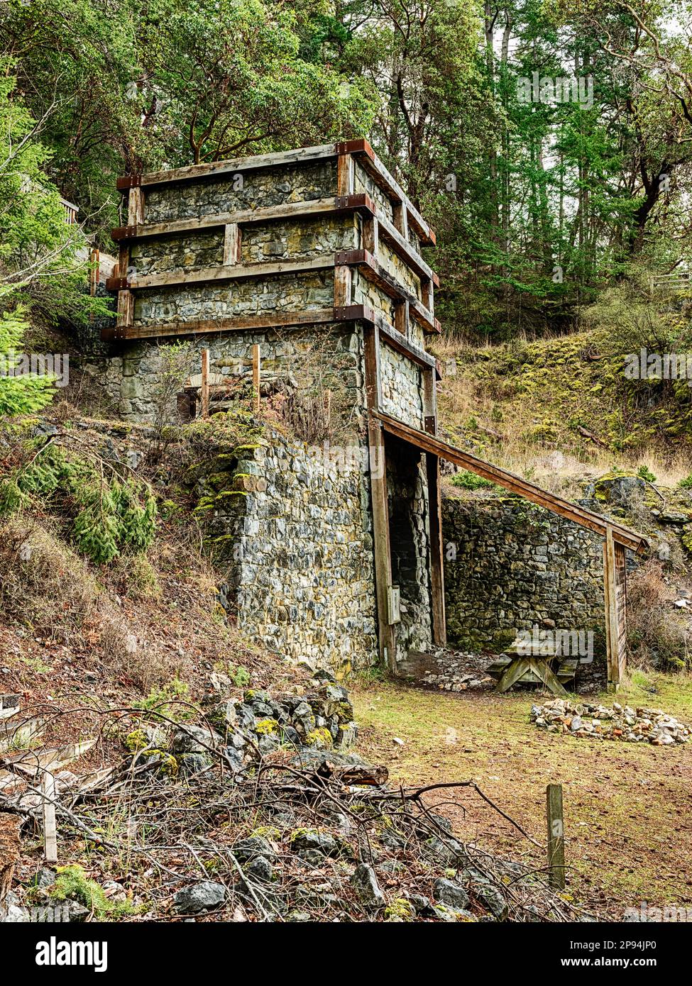 One of the restored old lime kilns on San Juan Island with a pile of extra rocks in the foreground. Stock Photo