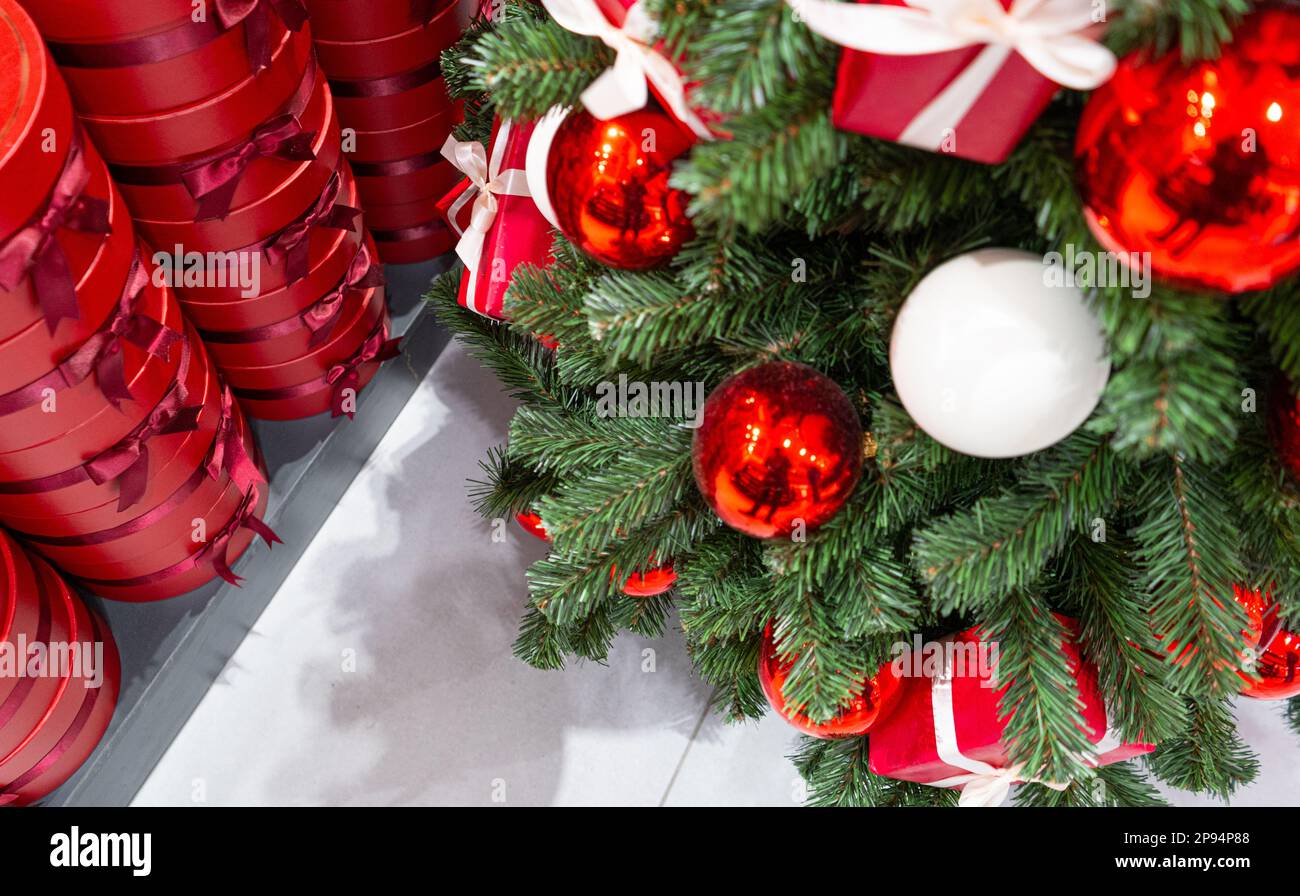 Decorated Christmas Tree, Red Gift Boxes, Christmas Decorations, Shiny Garland on Green Branches, Blurred Xmas Background with Copy Space Stock Photo