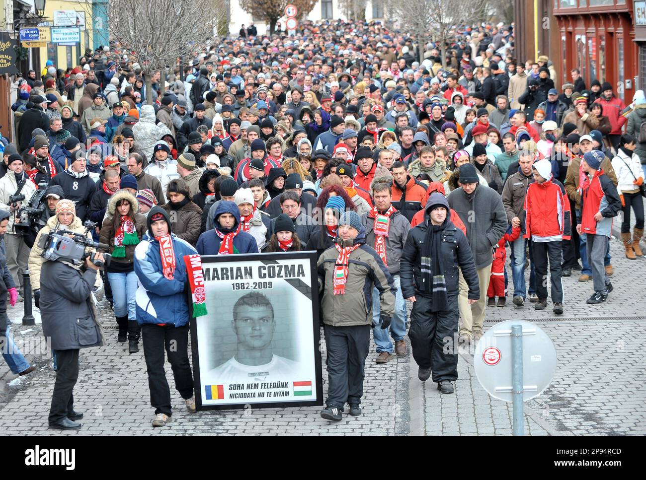 Fans carry a portrait of killed Romanian handball player Marian Cozma of the Hungarian club Veszprem MKB as following the call of the club thousands of people participate in a march to commemorate Cozma in Veszprem, 108 kms southwest of Budapest, Hungary, Sunday, Febr. 15, 2009. Marian Cozma, handball player of Veszprem MKB was stabbed through the heart and killed by criminals last Sunday in Veszprem and was buried in Bucharest last Friday. The inscriptions in Hungarian and Romanian read: ''We'll never forget you''. (AP Photo/MTI, Tibor Illyes) Stock Photo