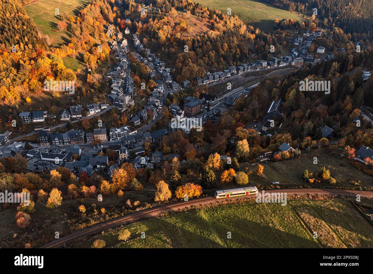 Germany, Thuringia, Lauscha, small town, train driving in last sunlight over town, oblique view Stock Photo