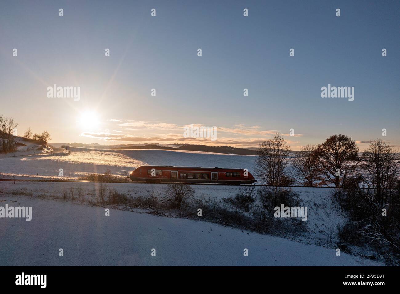 Germany, Thuringia, Bechstedt, regional train 60, train 29886, snow, sunset, side view, back light Stock Photo
