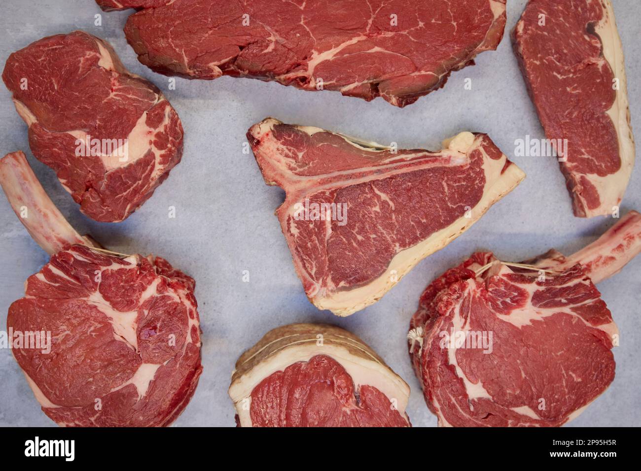 Overhead Shot Of Different Cuts Of Beef Steak On Background In Butcher's Shop Display Stock Photo