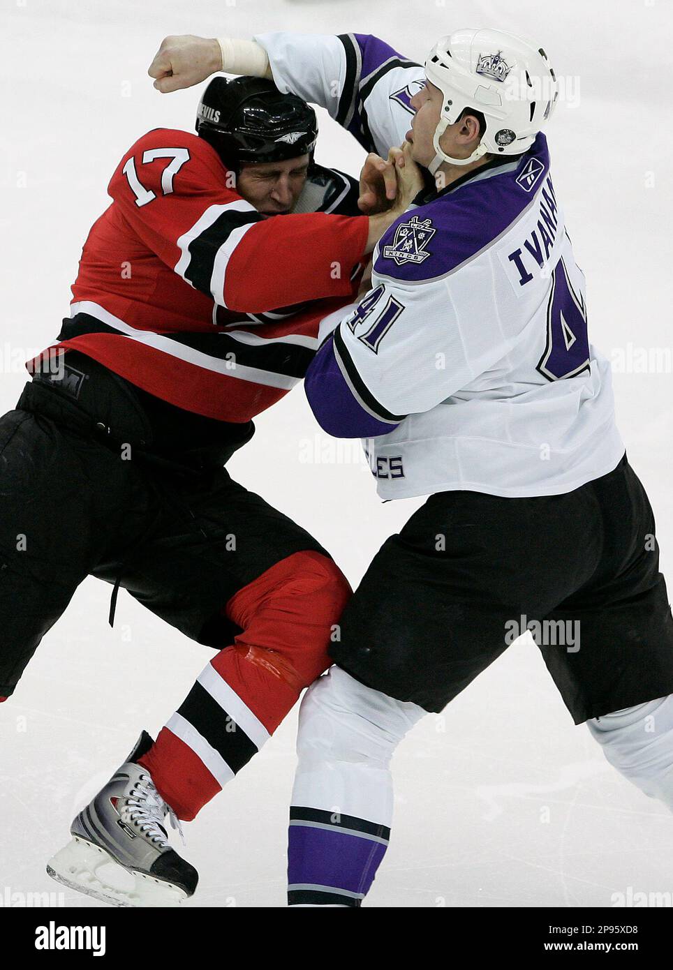 New Jersey Devils' Mike Rupp, left, ducks as Los Angeles Kings' Raitis ...