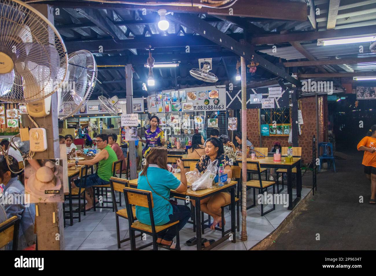 A traditional street restaurant with a narrow passage for scooters in