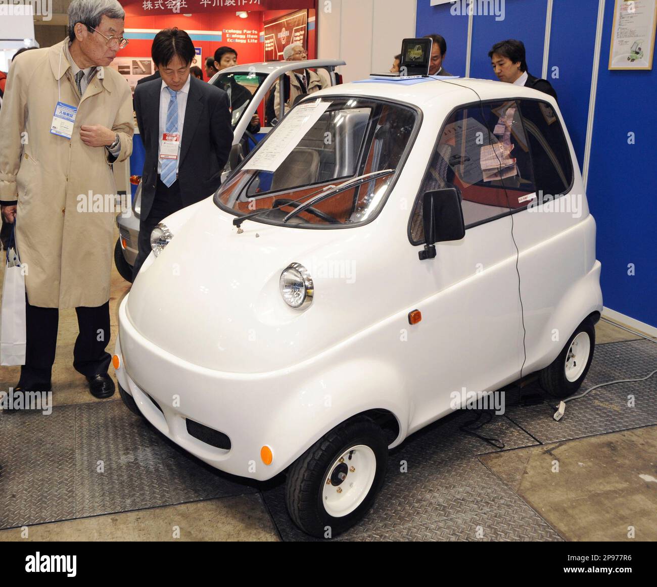 Visitors look at Japanes car maker Takeoka Auto Craft's electric  single-seater during a car electronics technology exhibition in Tokyo  Wednesday, Jan. 28, 2009. The ultra compact vehicle that runs at top speed