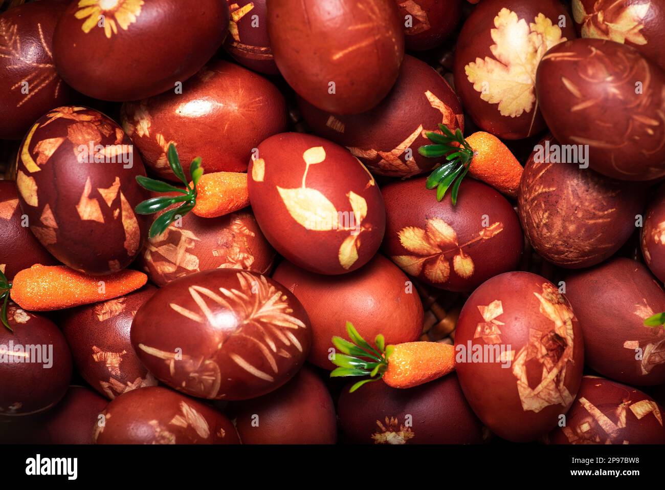 Traditional easter eggs dyed in onion peel. Light Easter holiday with carrots. Religious traditions. Stock Photo