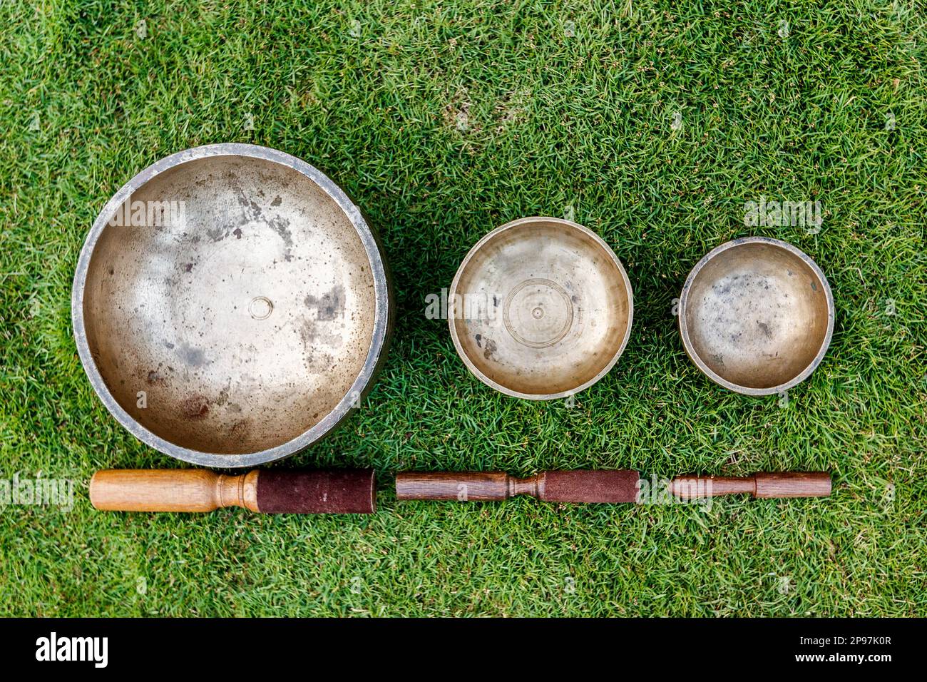 Ancient Tibetan singing bowls on green grass. Singing bowls for sound ...