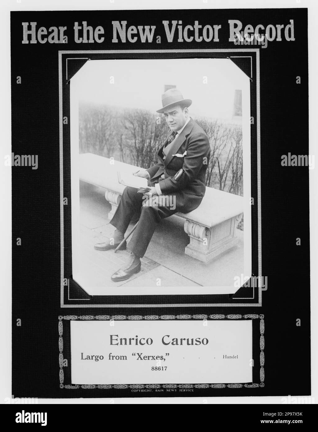 1916 ca, New York , USA : The italian Opera singer tenore  ENRICO CARUSO ( Napoli 1873 - 1921 ) advertising for the new 78rpm record XERXES ( by Handel ) for Victor Record Talking Machine .     -  MUSICA CLASSICA - CLASSICAL - MUSIC - portrait - ritratto - cappello - hat - collar - cravatta  - TENORE - OPERA LIRICA - TEATRO - THEATER -   -  reader - lettore - panchina - bastone da passeggio - pubblicita' ----   Archivio GBB Stock Photo