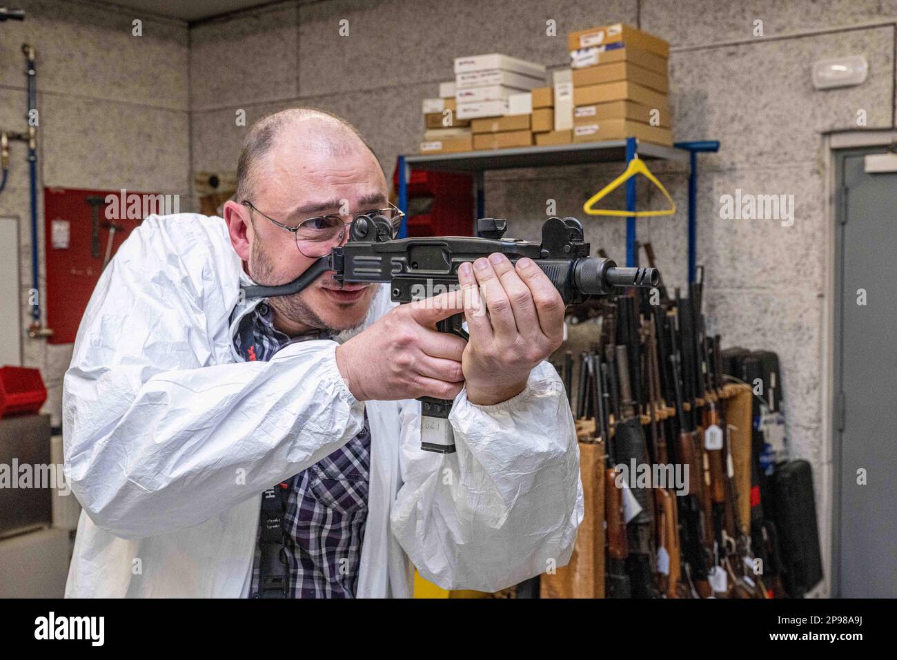 A ballistics expert handles an UZI machine gun during a visit to the
