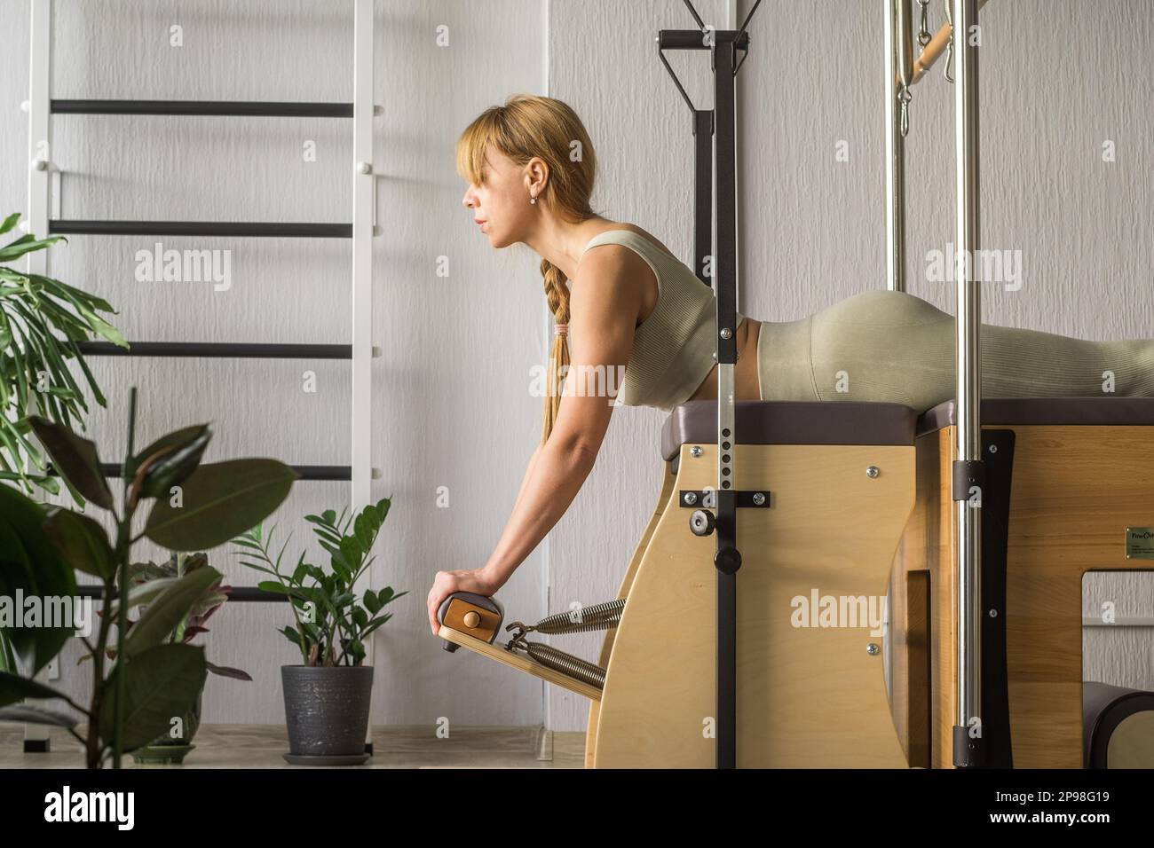 Pilates fitness trainer doing back strengthening exercises on in