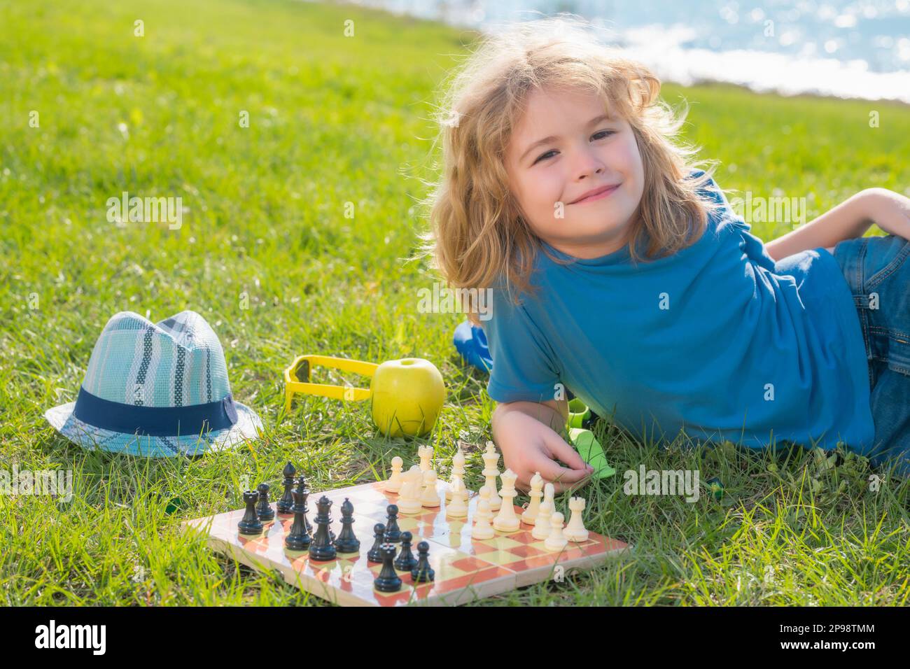 Child playing chess. Clever kid thinking about chess Stock Photo