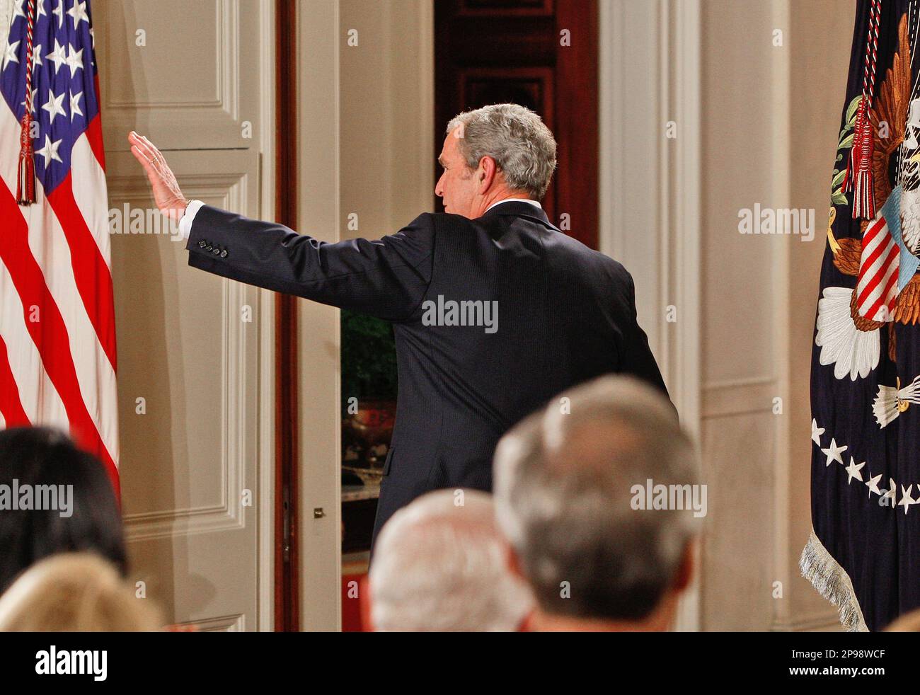 President George W. Bush waves as he leaves the room after giving a ...