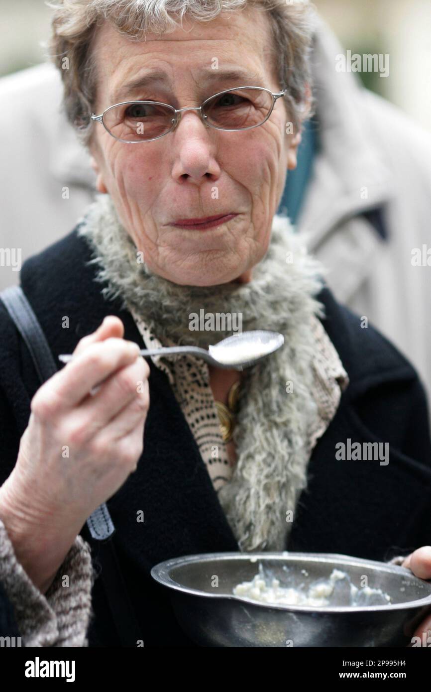 Gloria Holmes tastes a bowl of gruel serve out by the Royal Society of
