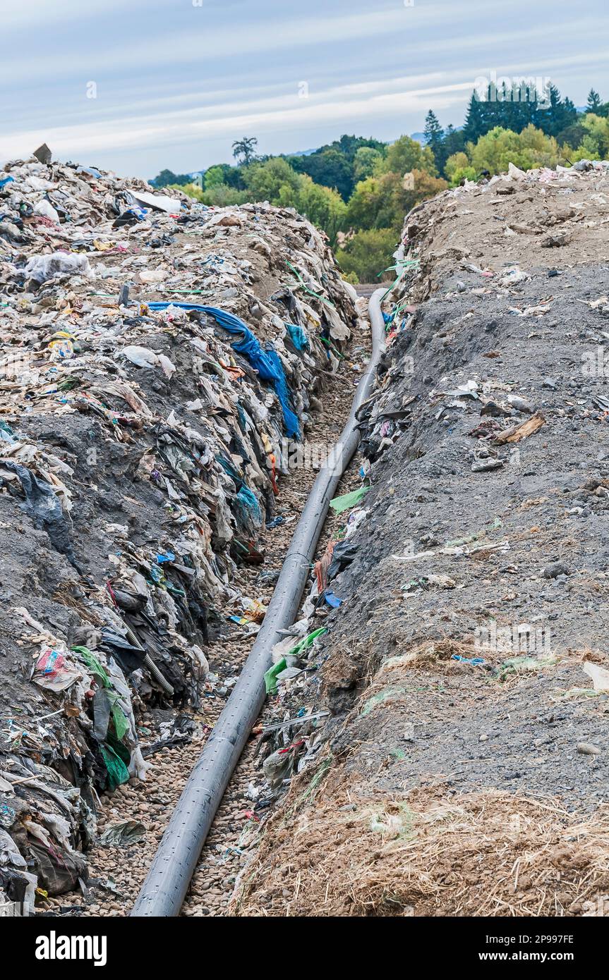 A perforated pipe for methane gas is laid in a trench to be buried in