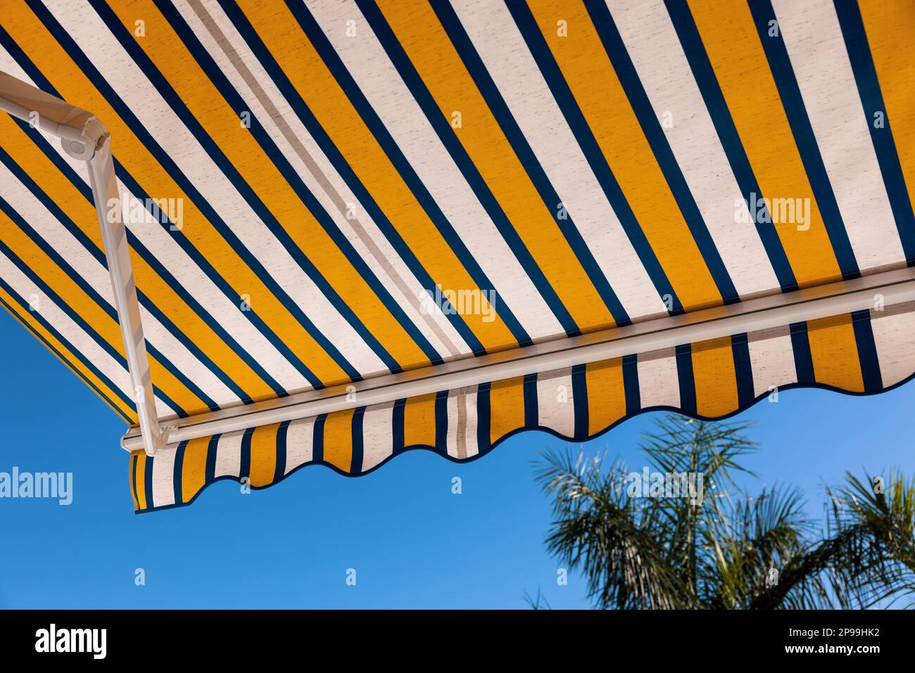 striped fabric awning against blue sky Stock Photo