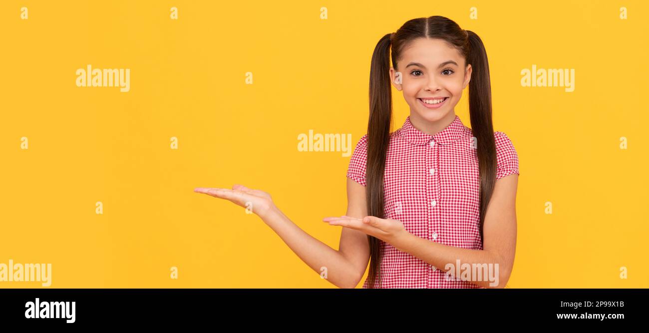 product proposal. cheerful kid presenting product, copy space. pretty teen  girl advertising. Child face, horizontal poster, teenager girl isolated por  Stock Photo - Alamy
