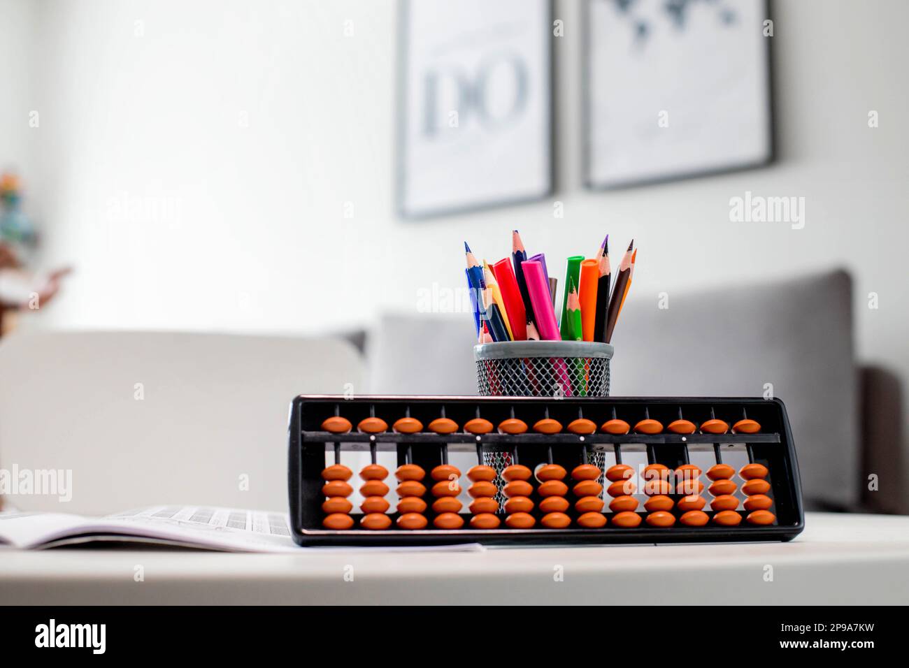 Abacus and colored pencils on a white table. Learning mental arithmetic Stock Photo