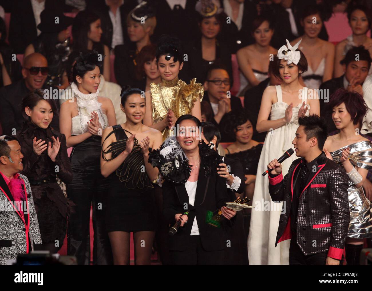 Hong Kong singer Miriam Yeung, center, holding her trophy, performs