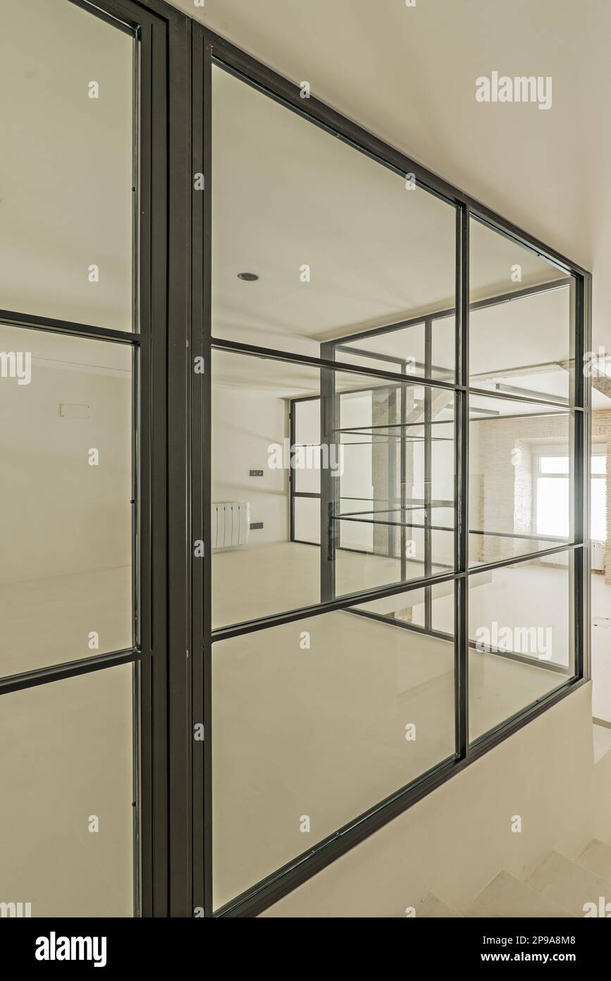 Metal and glass enclosure with a few angles of a loft with polished