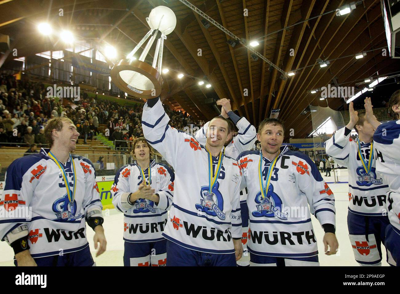 Dynamo Moscows players Peter Cajanek, which scored three time, next to Vitaly Yatchmenev, right, presents the winners trophy of the Spengler Cup after Dynamo Moscow won the final game between Team Canada