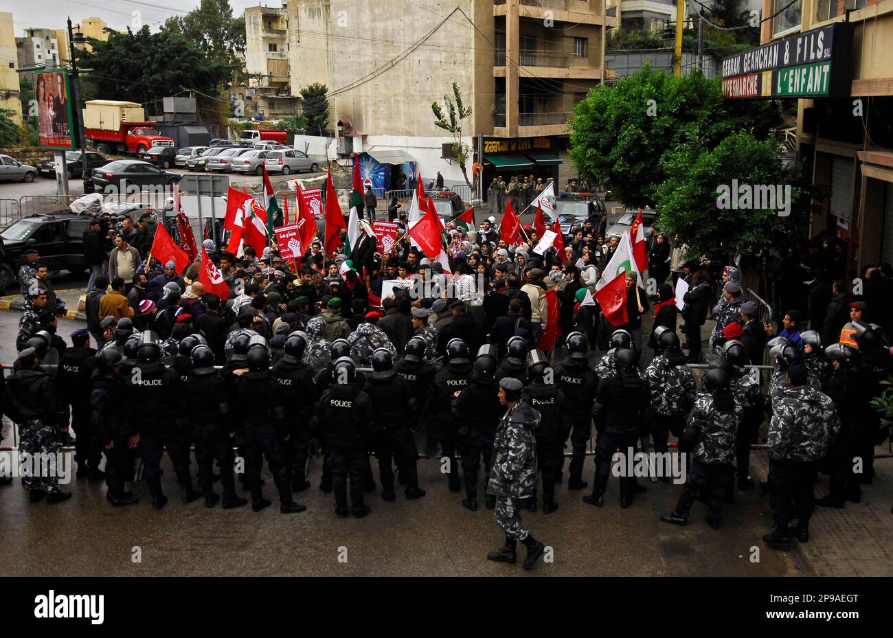 Riot police block the road leading to the Arab league headquarters as ...